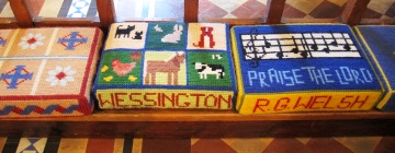 Handsewn kneelers in Wessington Church showing animals, tractors and music notes